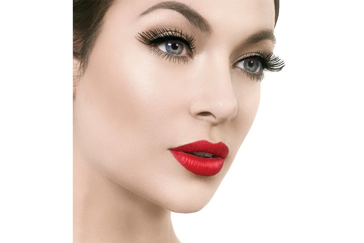 A glamorous combination of red lips and bold false lashes by Rita Stirpe