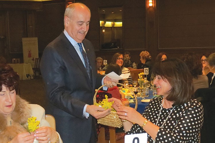 Associate Minister of National Defence Julian Fantino presents hundreds of local women with mimosa flowers on International Women’s Day