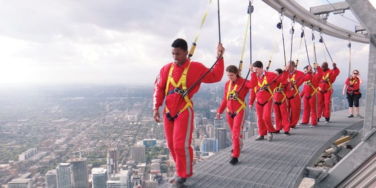 A group of journalists, and a nervous Ford representative, survey Toronto from 356 metres up during the EdgeWalk